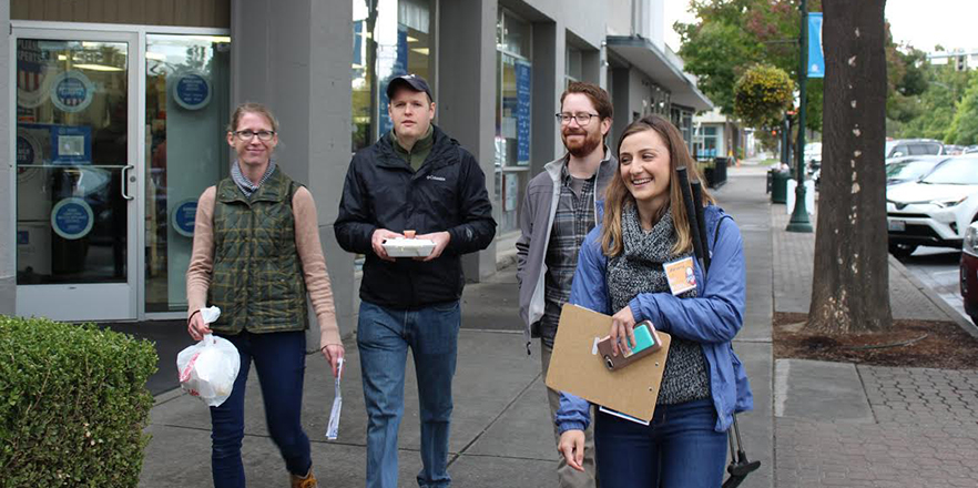 A group of people walk down a street.