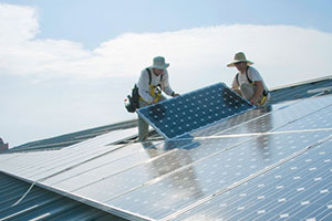 Two Whitman staff installing solar panels on roof.