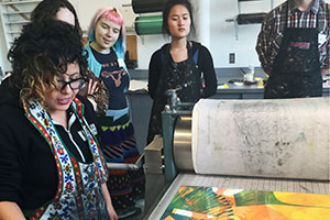 Artist Favianna Rodriguez demonstrates her printmaking techniques for a group of Whitman students
