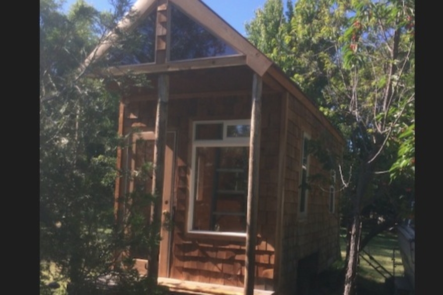 image of the front of a tiny house surrounded by trees