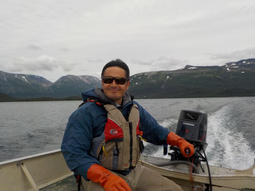 Tyler Dann driving a boat across a body of water