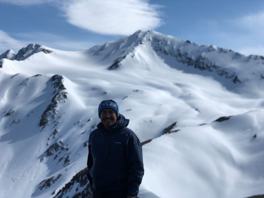 Tyler Dann on a snowy mountain summit