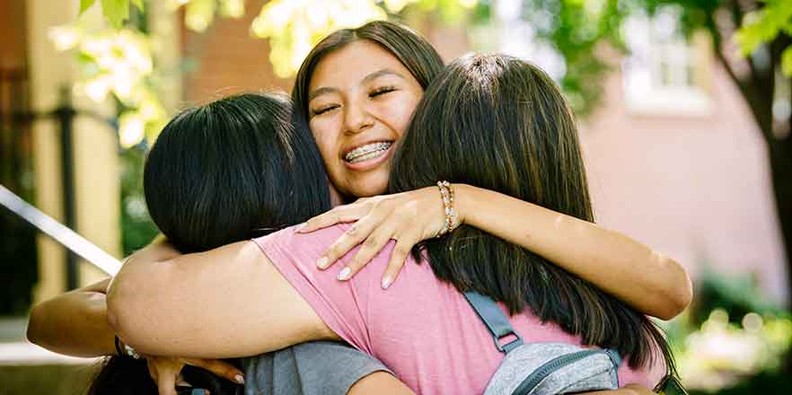 Student embracing her family on move-in day.