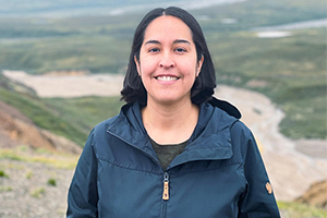 Amber Ebarb, smiling, standing outdoors, wearing a dark blue jacket.