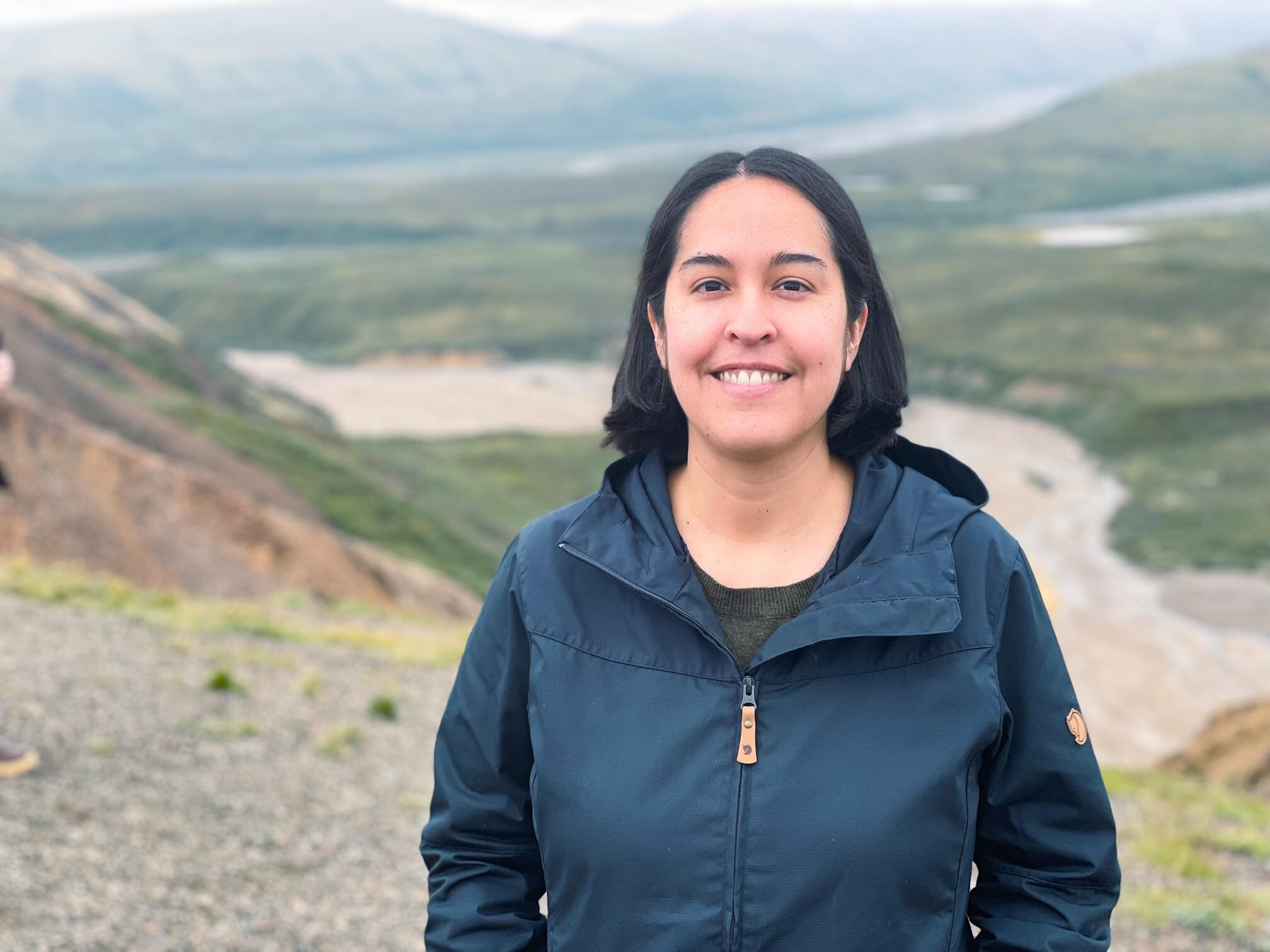 Amber Ebarb, smiling, standing outdoors, wearing a dark blue jacket.