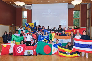 Dozens of students holding flags from around the world.