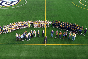 A group of Whitman athletes and Whitman community members gathering at the new Whitman turf field