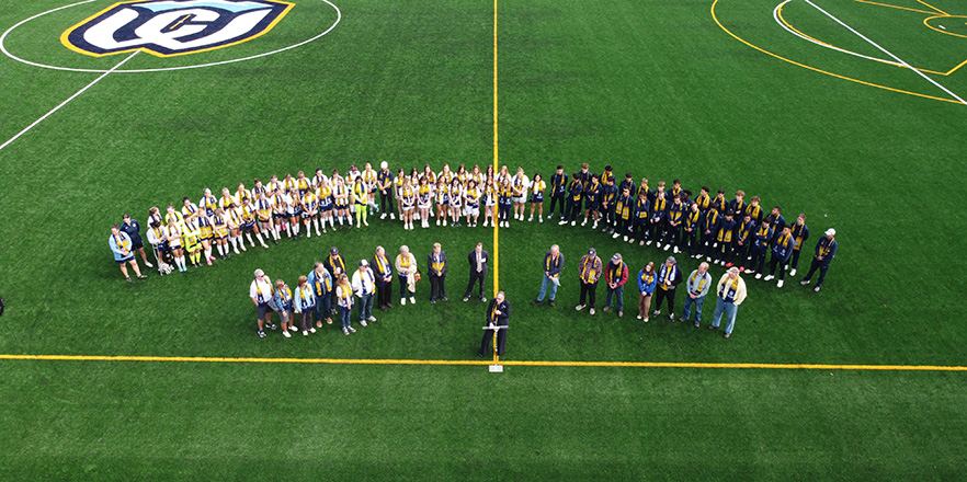 A group of Whitman athletes and Whitman community members gathering at the new Whitman turf field