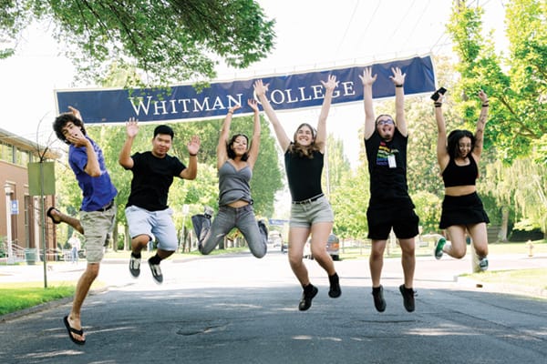 Whitman students jumping in excitement in front of a Whitman sign