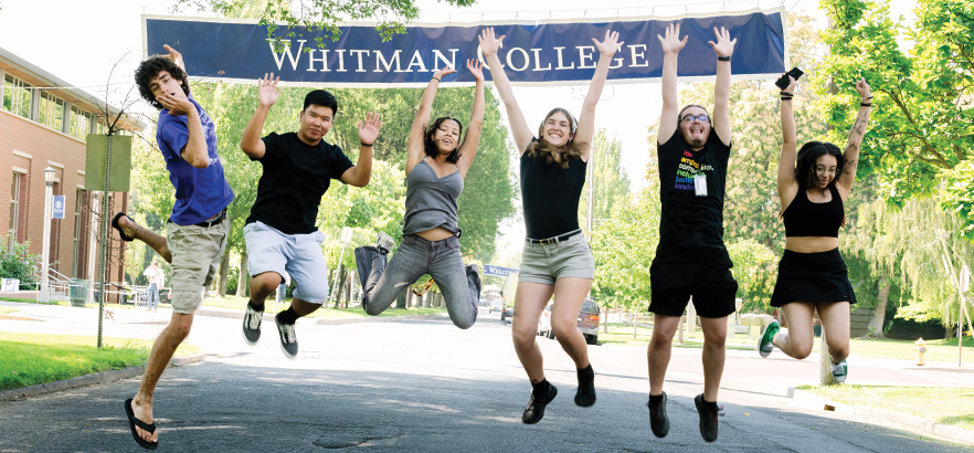 Whitman students jumping in excitement in front of a Whitman sign