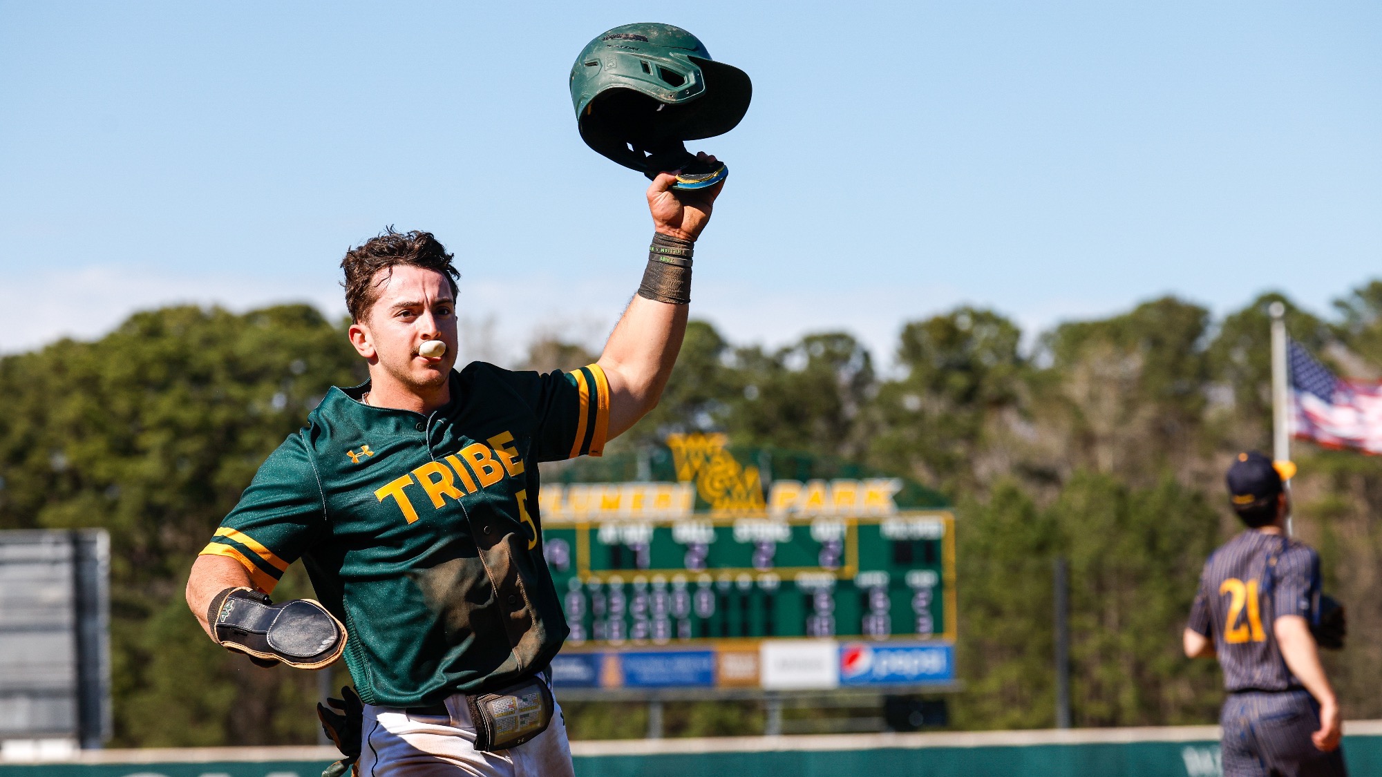 Ben Parker on a baseball field wearing a green baseball uniform.