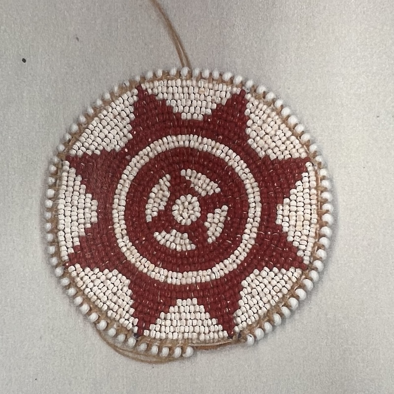 The Sun and Fire medallion designed by Roger Amerman