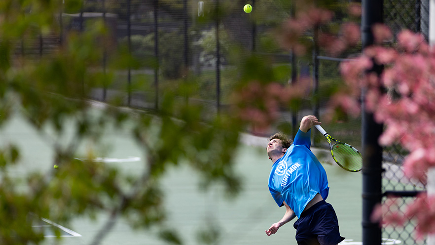 Alexander Stage mid air about to serve a tennis ball.