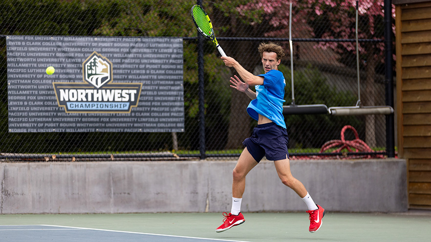 Alexander Stage mid return of a tennis ball with his forehand.