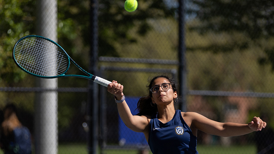 Ilina Jha returning a tennis ball with her forehand.