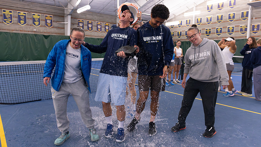 2024-25 Whitman Women's Tennis coaching staff being drenched in water.