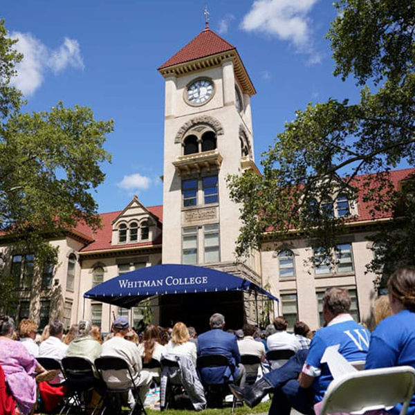A crowd sits in front of Memorial Building during commencement.