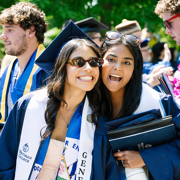 Whitman College Class of 2025 graduates smiling towards the camera.